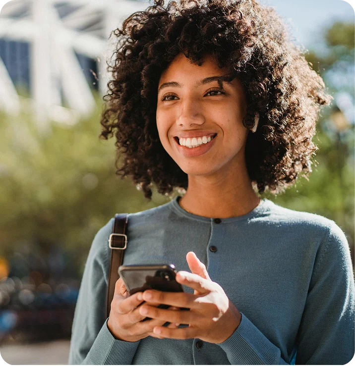 A founder out in the city, smiling at her phone