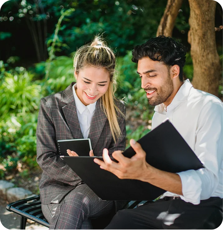 Two founders on a park bench, going through a plan together
